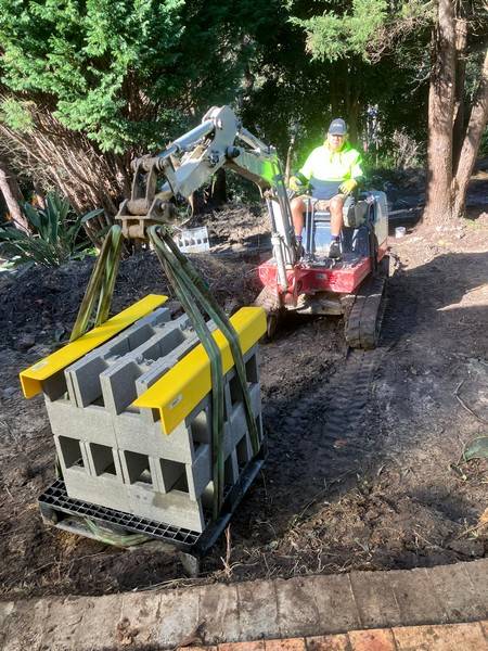 Retaining wall block handling - Allsites Excavations Sydney Compact tracked machine moving retaining wall blocks on a tight Sydney site