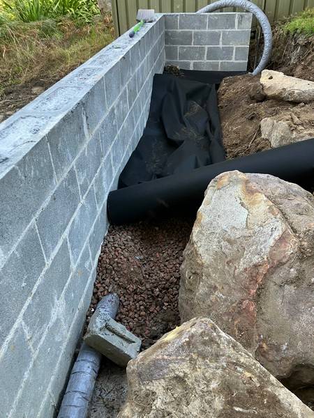 Retaining wall drainage - Allsites Excavations Sydney Drainage pipe installed behind a concrete block retaining wall in Sydney