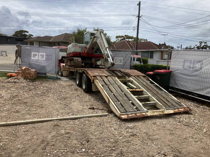 Machine delivery - Allsites Excavations Sydney Excavator unloaded from a truck for operated plant hire in Sydney