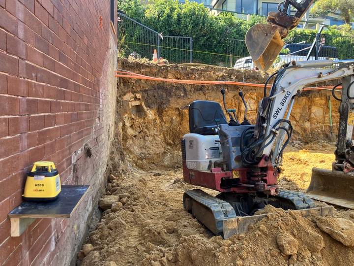 Narrow boundary excavation - Allsites Excavations Sydney Mini excavator in a narrow residential cut beside a brick boundary wall in Sydney
