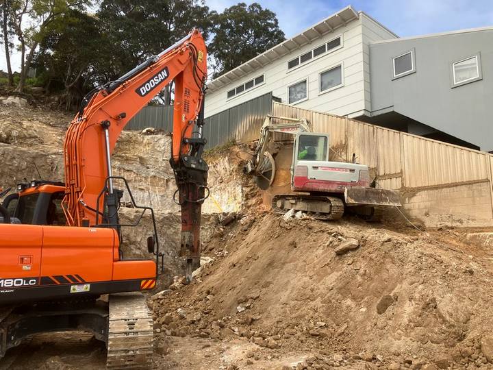 Excavator load-out - Allsites Excavations Sydney Excavator loading soil into a tipper truck during Sydney retaining wall excavation